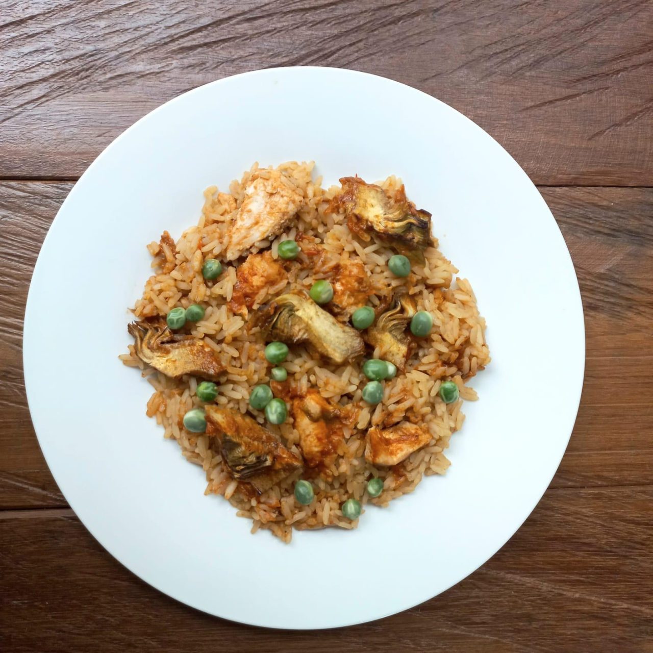 Paella de pollo y cerdo con alcachofas